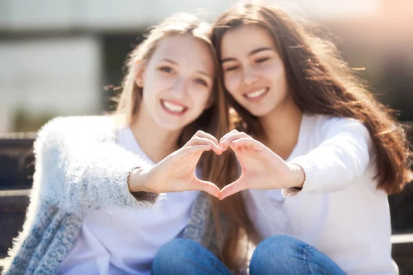 Dos niñas sosteniendo las manos en forma de corazón —  Fotos de Stock