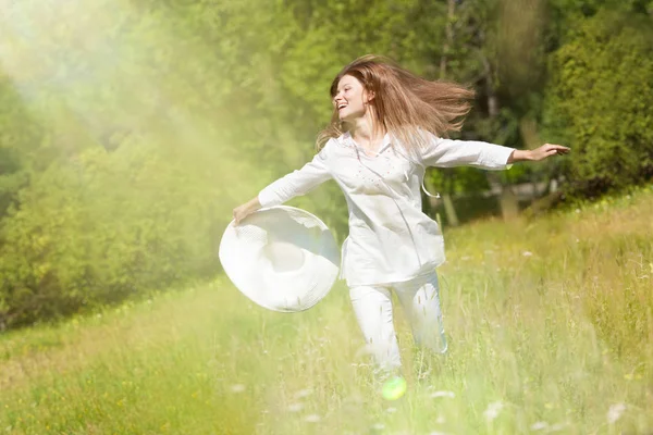 Mutlu genç kadının yaz yeşil çayır üzerinde. — Stok fotoğraf