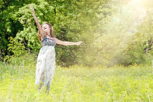 Mutlu genç kadının yaz yeşil çayır üzerinde. — Stok fotoğraf