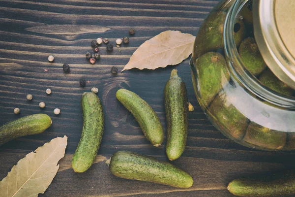 Pepinos verdes, pimenta, folha de louro na mesa de madeira — Fotografia de Stock