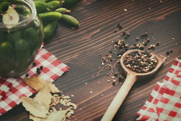 Pepinos verdes, pimenta, folha de louro na mesa de madeira — Fotografia de Stock