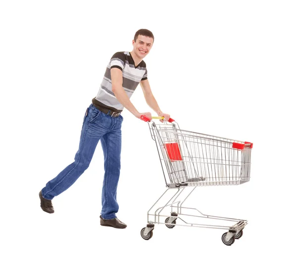 Junger Mann läuft mit leerem Einkaufswagen auf weißem Hintergrund — Stockfoto