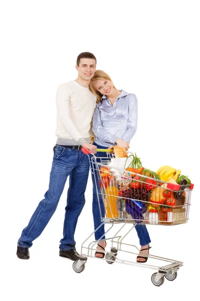 Pareja joven de pie con carro de la compra — Foto de Stock