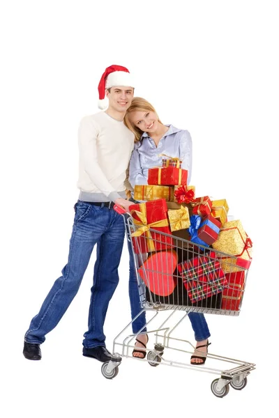 Junges Paar steht mit Einkaufswagen voller Weihnachtsgeschenke — Stockfoto