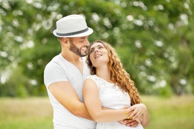 Mutlu genç Embrasing, yeşil çayır çift