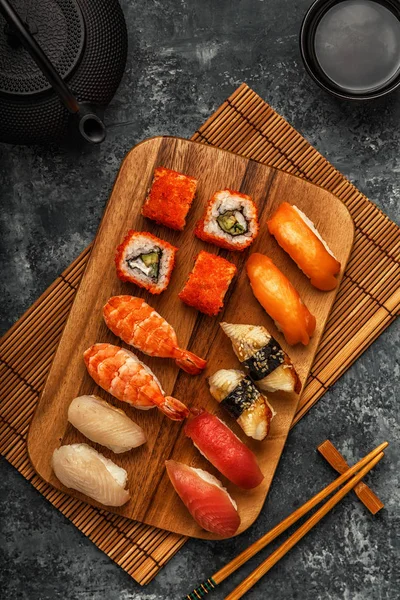 Sushi Set: sushi and sushi rolls on wooden plate.