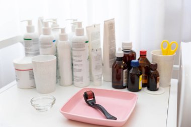 İlaçlar ve kozmetik ürünleri bir güzellik salonundaki aletlerle bir masada duruyor.