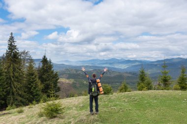 Yürüyüşçü ekipmanlarıyla dağlarda yürüyüş yapar.