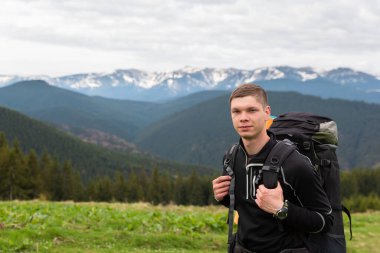 Yürüyüşçü ekipmanlarıyla dağlarda yürüyüş yapar.