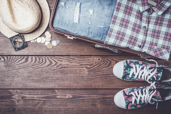 Resor bakgrund med öppen resväska och tillbehör. — Stockfoto