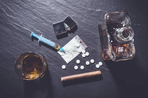 Hard drugs en alcohol op donkere stenen achtergrond — Stockfoto