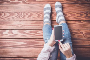 Akıllı telefon kullanan genç bir kadın.