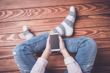 Akıllı telefon kullanan genç bir kadın.