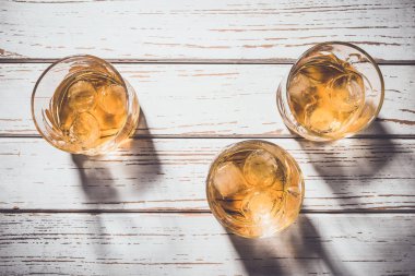 Viski bardağı buz küpleriyle eski ahşap masa