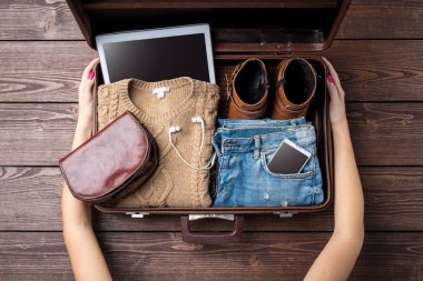 Hazırlıklar kavramı açık bavul ve kadının rahat kıyafetler ile seyahat