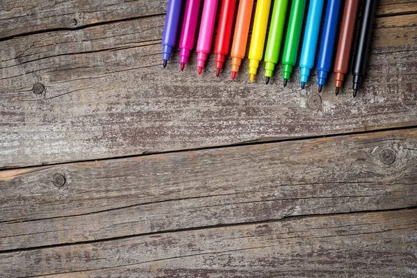 Overhead shot of colorful markers on wooden table — Stock Photo, Image