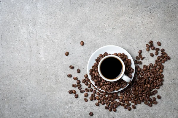 Xícara de café com grãos de café no fundo de pedra cinza — Fotografia de Stock