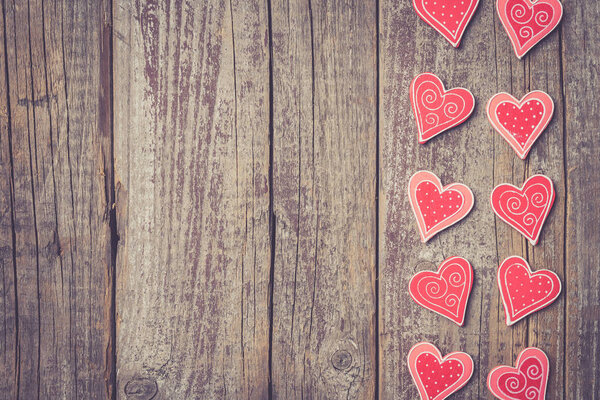 Red hearts on an old wooden table. Valentine's Day background