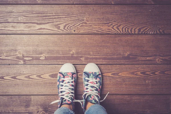 Mujer de pie en el suelo de madera en zapatillas de colores . — Foto de Stock