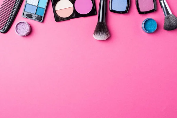 Makeup products on pink background