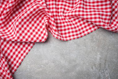 Gri taş masada kırmızı katlanmış masa örtüsü. Üstten Görünüm