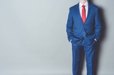 Mavi siut ve gri arka plan kırmızı kravat giyen başarılı işadamı portresi