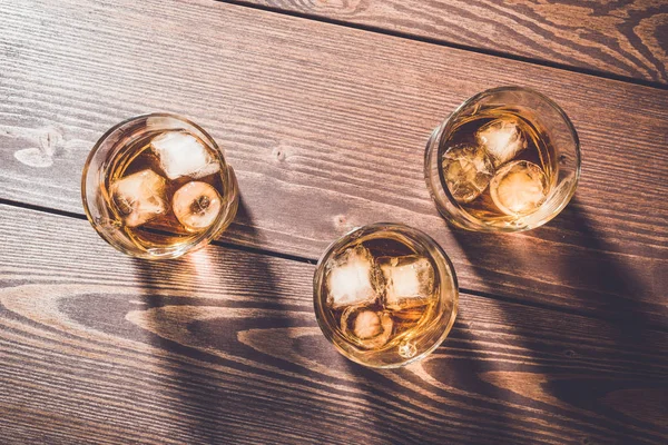 Glasses of whiskey on an old wooden table