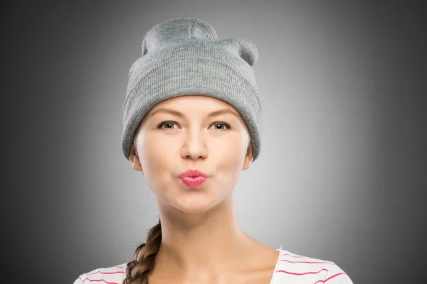 迷人的年轻妇女在冬天帽子送亲吻 — 图库照片