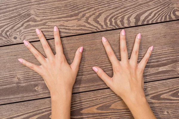 Mãos Femininas Com Unhas Cor Rosa Mesa Madeira — Fotografia de Stock