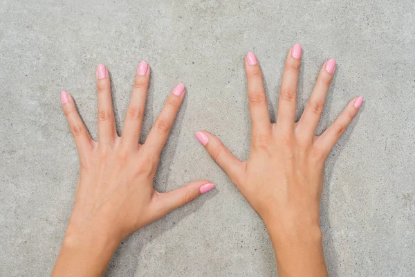 Frauenhände Mit Rosa Nägeln Auf Grauem Steintisch — Stockfoto