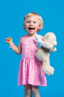 Mavi arka plan karşı pembe elbiseli güzel genç kız portresi