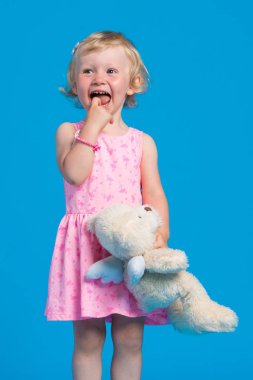 Mavi arka plan karşı pembe elbiseli güzel genç kız portresi