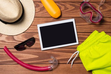 Ahşap masa üzerinde beyaz dijital tablet ile yaz aksesuarları