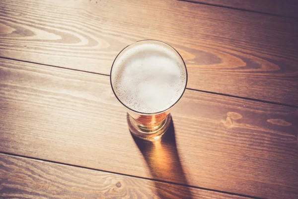 Beer glass on wooden table — Stock Photo, Image