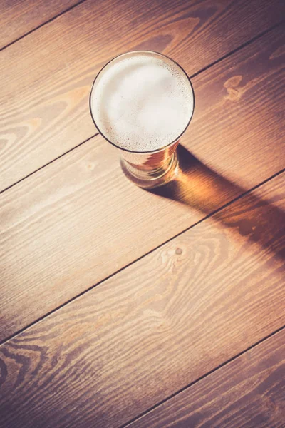 Copo de cerveja na mesa de madeira — Fotografia de Stock