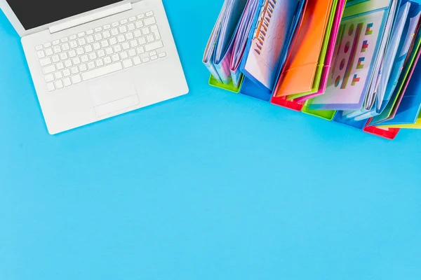 Blue office table with laptop and documents