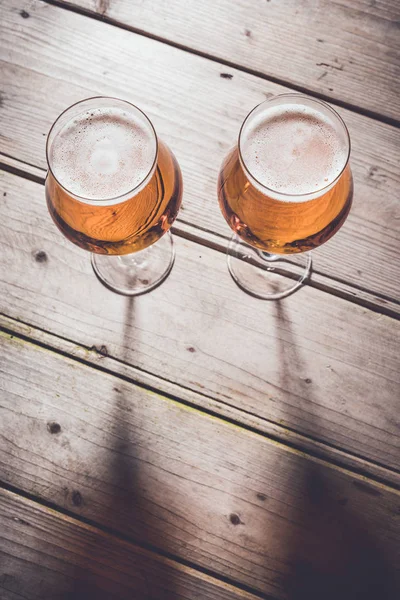 Glasses of beer on an old wooden table. — Stock Photo, Image