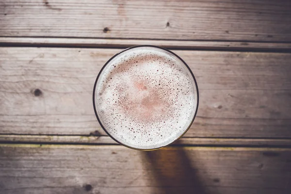 Verre de bière sur une vieille table en bois . — Photo