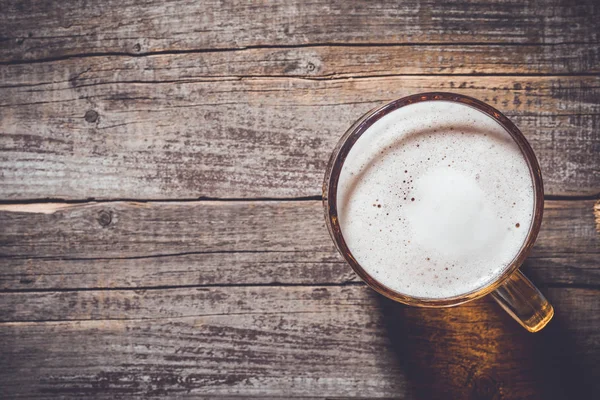 Mug of beer on an old wooden table — Stock Photo, Image