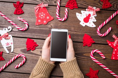 Akıllı telefon ahşap masa üzerinde tutan kadın.