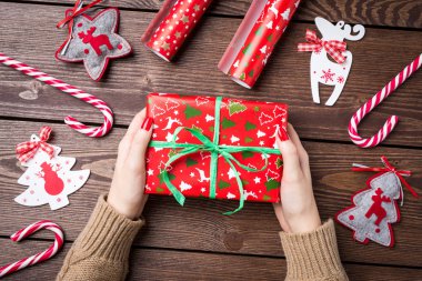 Noel hediyesi ahşap masa üzerinde tutan kadın