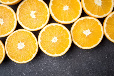 Taze ve sulu yarım portakal karanlık taş masanın üstüne kesmek.