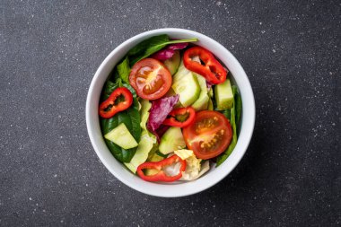 Karanlık taş masada sebze salatası