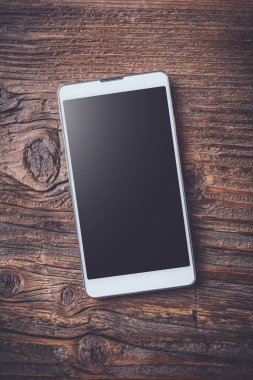 Eski bir ahşap masa beyaz akıllı telefon