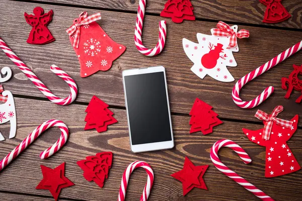 Decorações de Natal com telefone inteligente branco em uma mesa de madeira velha — Fotografia de Stock