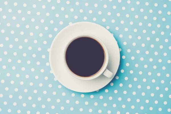 Cup of coffee on blue dotted background