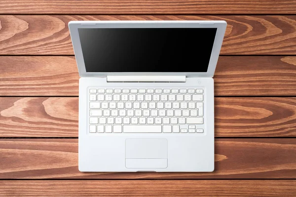 Overhead shot of white laptop on wooden table — Stock Photo, Image