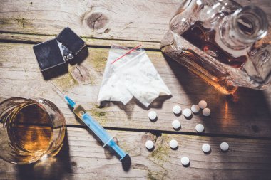 Ağır uyuşturucu ve alkol ahşap masa üzerinde havai çekim.