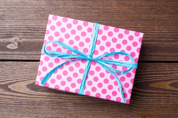 Pink dotted gift box on wooden table — Stock Photo, Image
