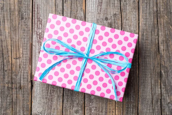 Pink dotted gift box on wooden table — Stock Photo, Image